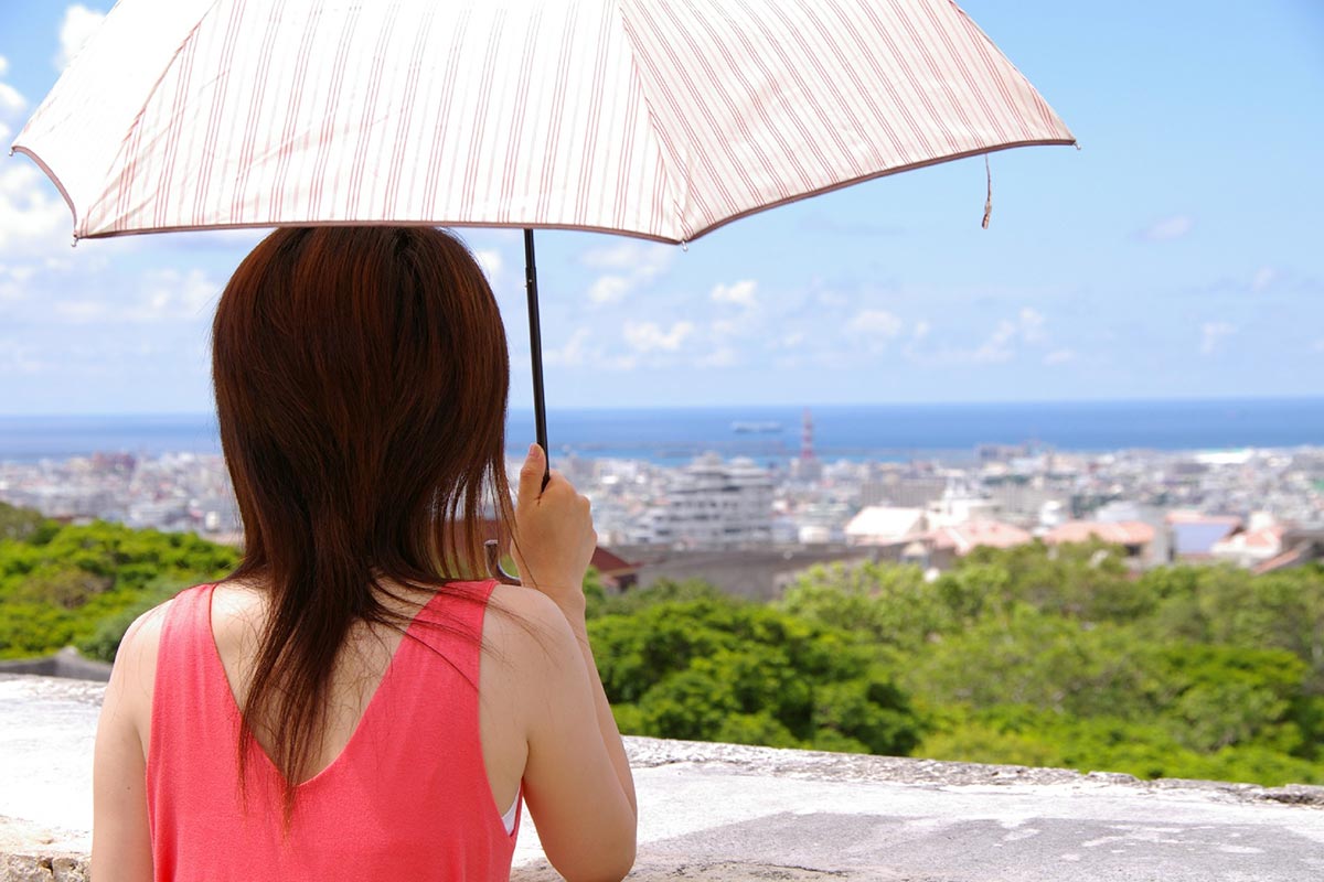 暑さの中、日傘をさす女性