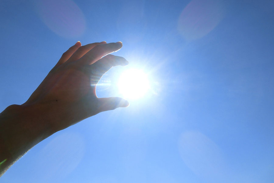 照りつける太陽をつまむ手