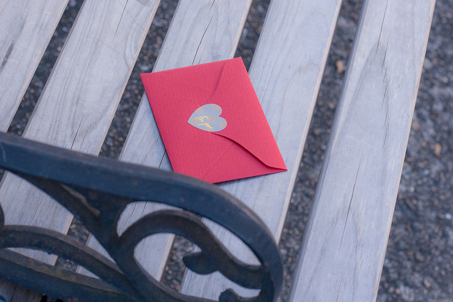 公園のベンチに置かれた赤い封筒に入ったラブレター