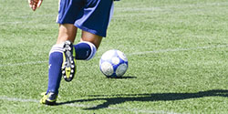 ボールを追いかけるサッカー選手の足