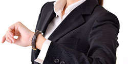時計を確認するスーツ姿の女性の手