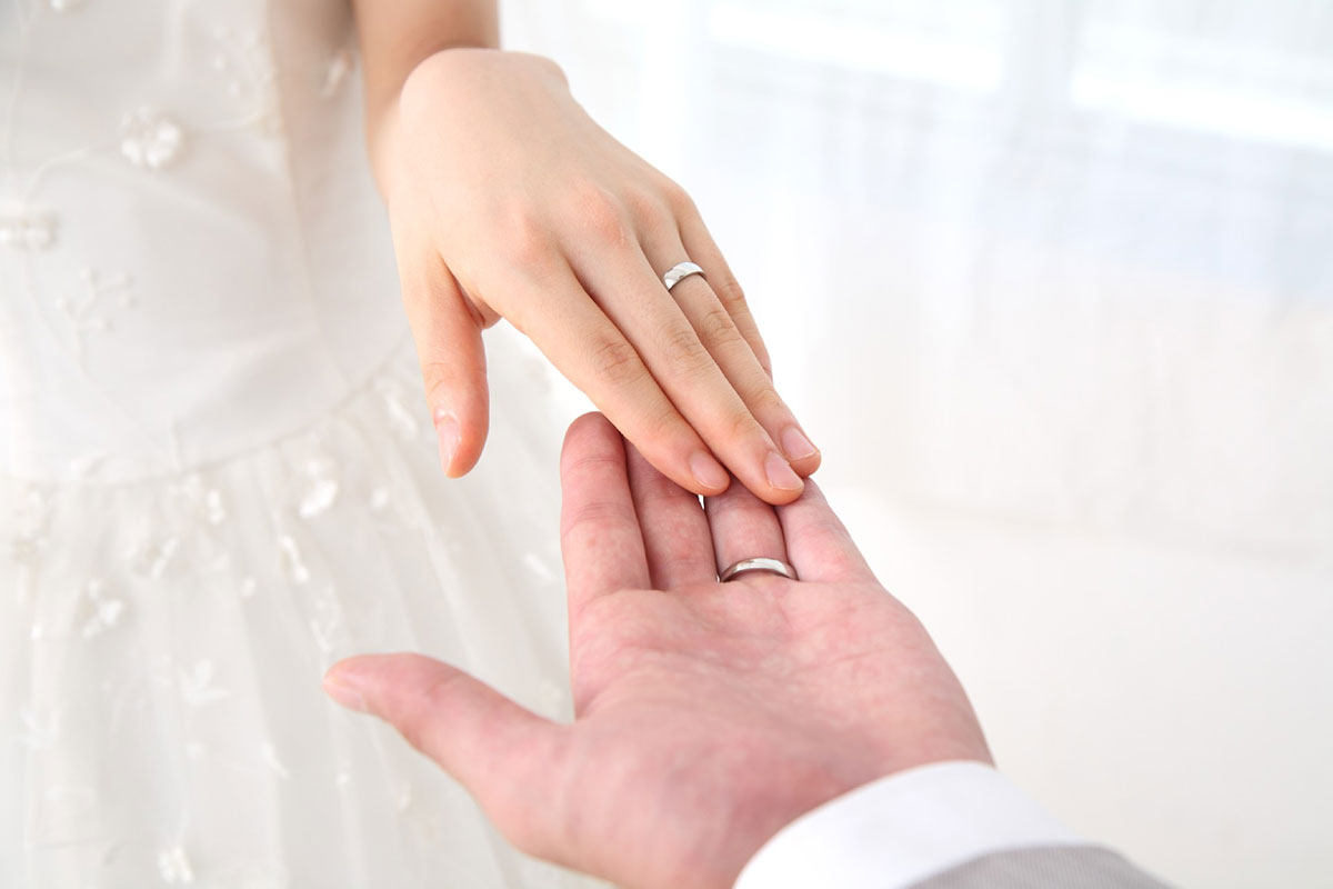 手を繋ごうとする結婚指輪を嵌めた男女
